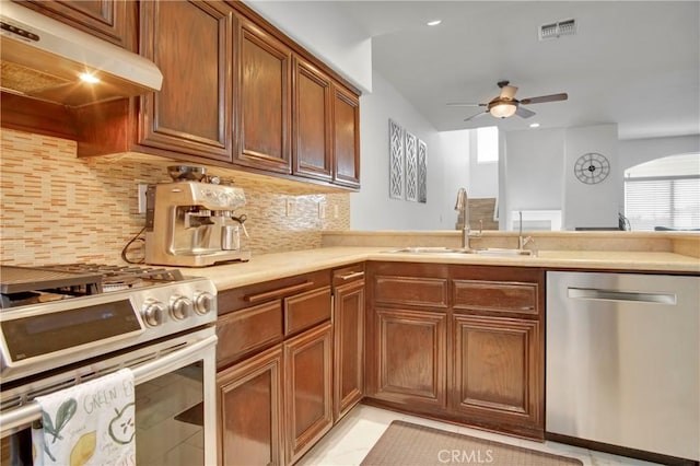 kitchen featuring sink, backsplash, stainless steel appliances, and ceiling fan