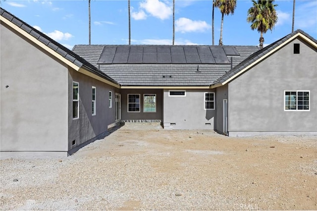 back of property featuring solar panels