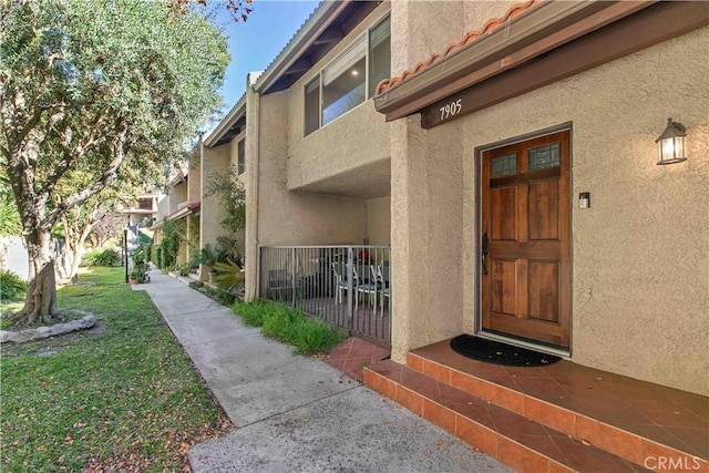 entrance to property featuring a lawn