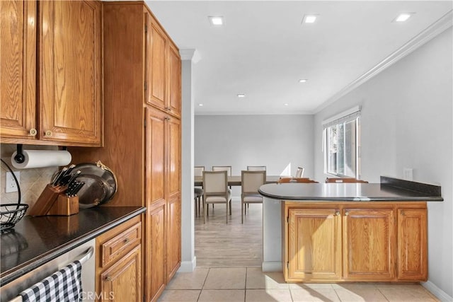 kitchen with kitchen peninsula, light tile patterned floors, crown molding, and tasteful backsplash