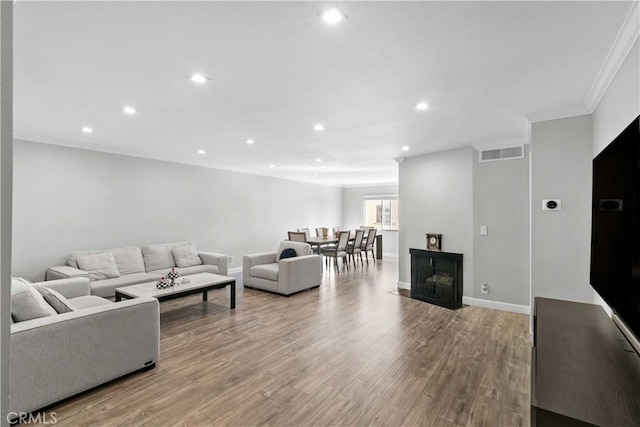 living room with light wood-type flooring and crown molding