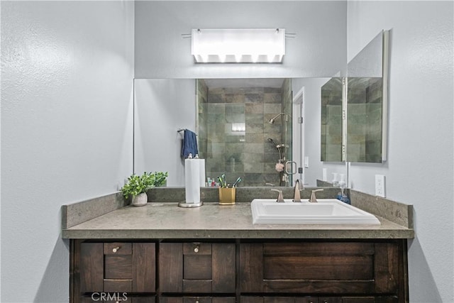 bathroom with vanity and a tile shower