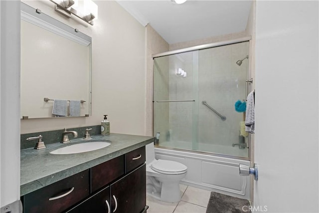 full bathroom with tile patterned floors, vanity, bath / shower combo with glass door, and toilet