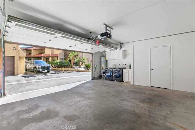 garage featuring washer and dryer, a garage door opener, and water heater