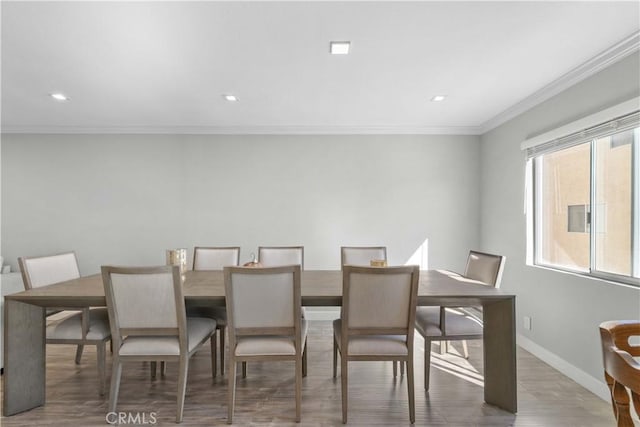 dining space featuring hardwood / wood-style flooring and ornamental molding