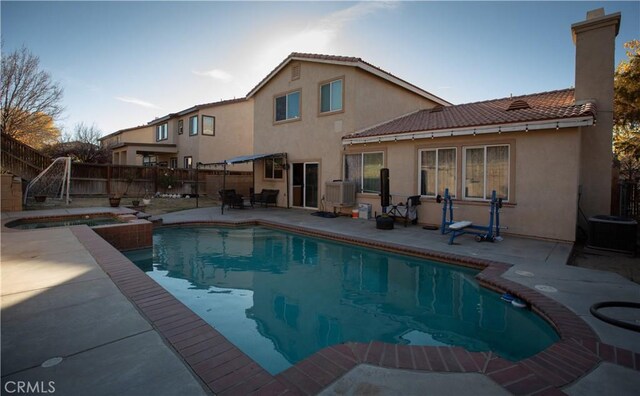 view of swimming pool with an in ground hot tub, a patio, and central air condition unit