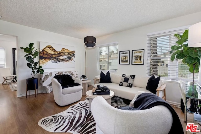 living room with dark hardwood / wood-style flooring and a textured ceiling