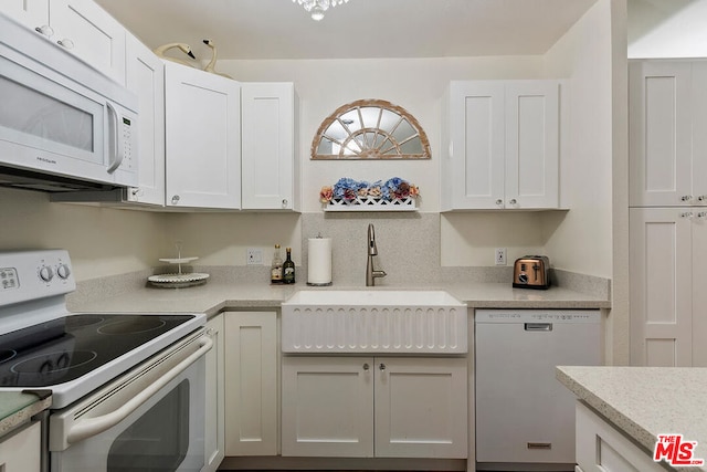 kitchen featuring white cabinets, white appliances, and sink