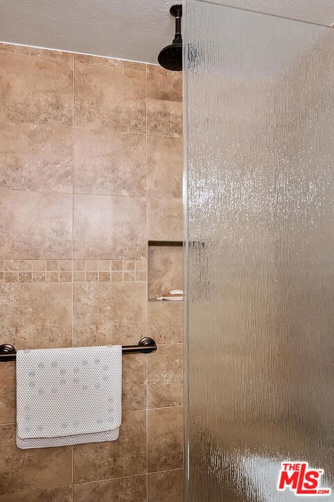 interior details with a tile shower