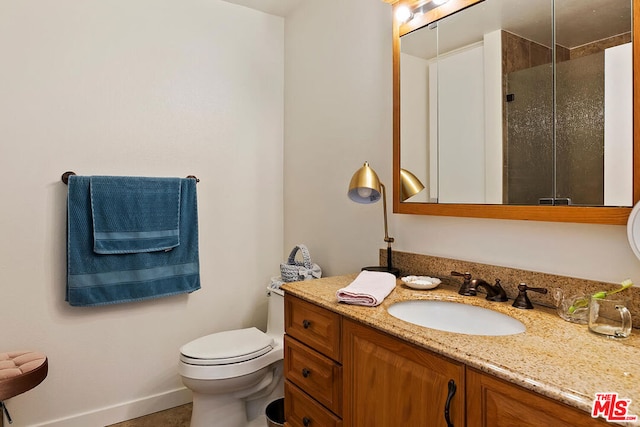 bathroom featuring vanity, toilet, and a shower with shower door