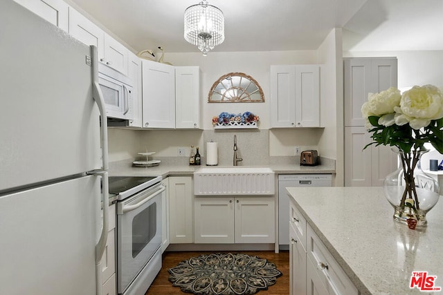 kitchen with white cabinets, white appliances, decorative light fixtures, and sink