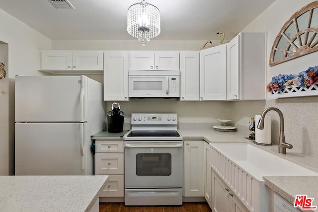 kitchen featuring white cabinets, white appliances, and a notable chandelier