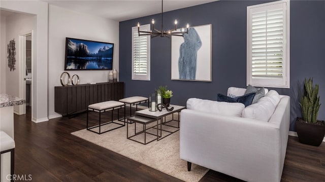 living room featuring a notable chandelier, a healthy amount of sunlight, and dark hardwood / wood-style flooring