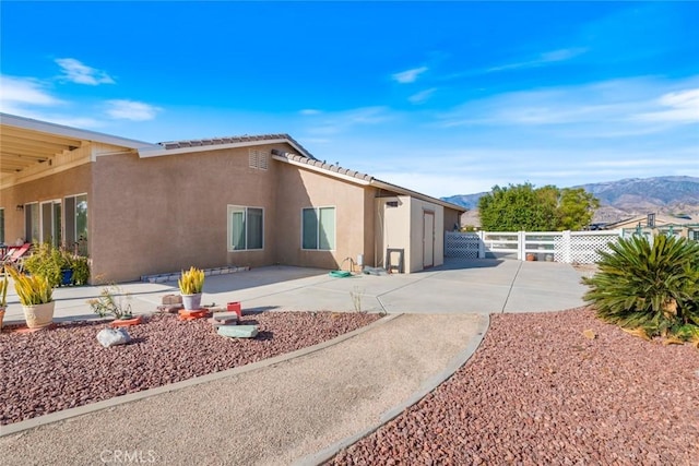 rear view of house featuring a mountain view and a patio