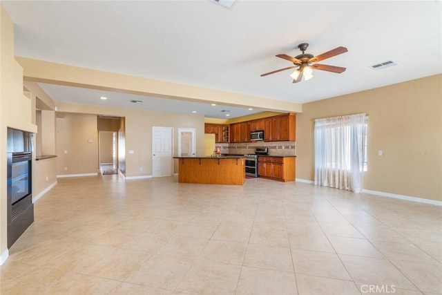 kitchen with appliances with stainless steel finishes, a kitchen island, backsplash, ceiling fan, and light tile patterned floors