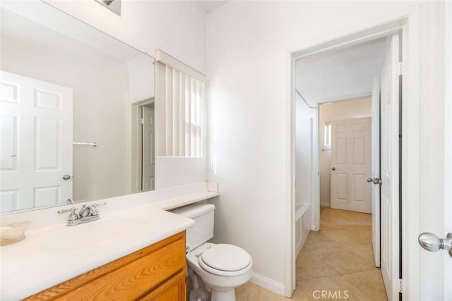 bathroom with toilet, vanity, and tile patterned floors