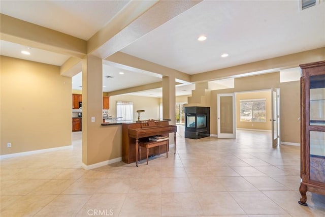 kitchen with light tile patterned floors, kitchen peninsula, and a wealth of natural light