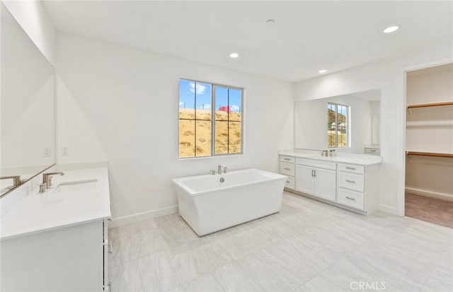 21235 Wildflower Way, Chatsworth, CA 91311 - bathroom featuring two vanities, healthy amount of natural light, a freestanding tub, recessed lighting, and a walk in closet