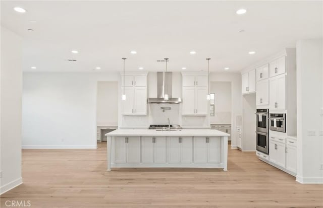 21235 Wildflower Way, Chatsworth, CA 91311 - kitchen with wall chimney exhaust hood, stainless steel double oven, light countertops, light wood finished floors, and recessed lighting