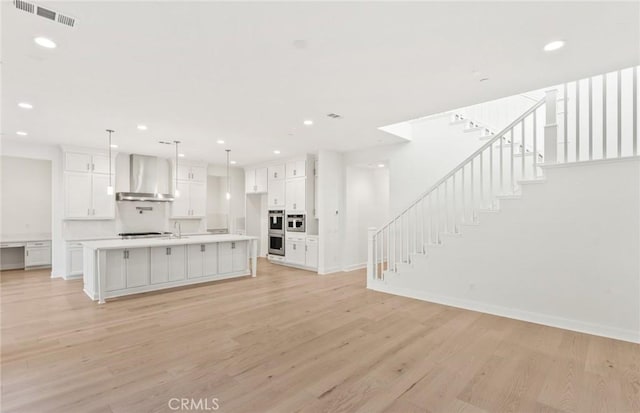 21235 Wildflower Way, Chatsworth, CA 91311 - kitchen featuring wall chimney range hood, light wood-style flooring, light countertops, recessed lighting, and appliances with stainless steel finishes