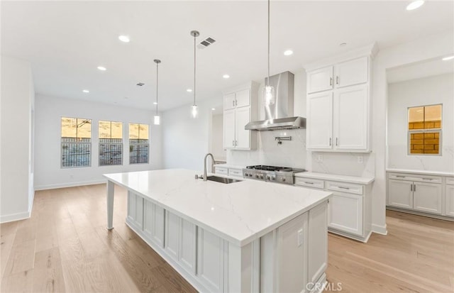 21235 Wildflower Way, Chatsworth, CA 91311 - kitchen featuring wall chimney exhaust hood, light wood-style floors, a large island with sink, white cabinets, and recessed lighting