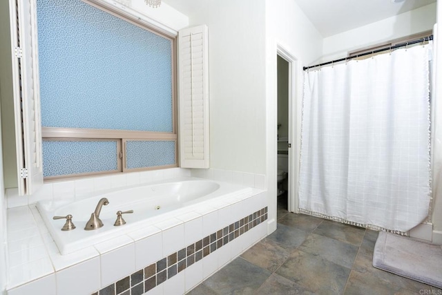 bathroom featuring toilet and tiled tub