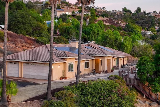 exterior space with a garage and solar panels