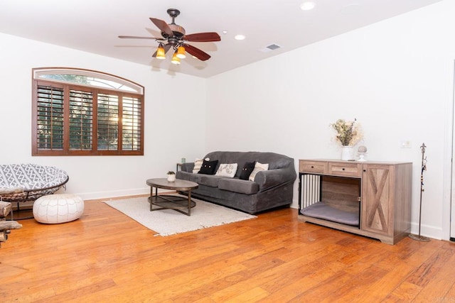 living room featuring ceiling fan and light hardwood / wood-style floors