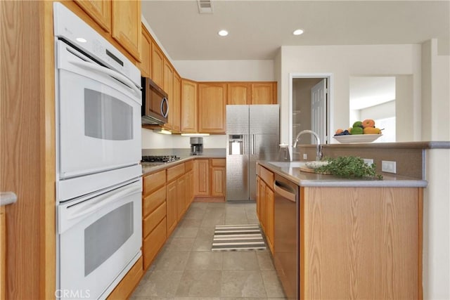 kitchen featuring sink, light tile patterned flooring, light brown cabinets, and appliances with stainless steel finishes