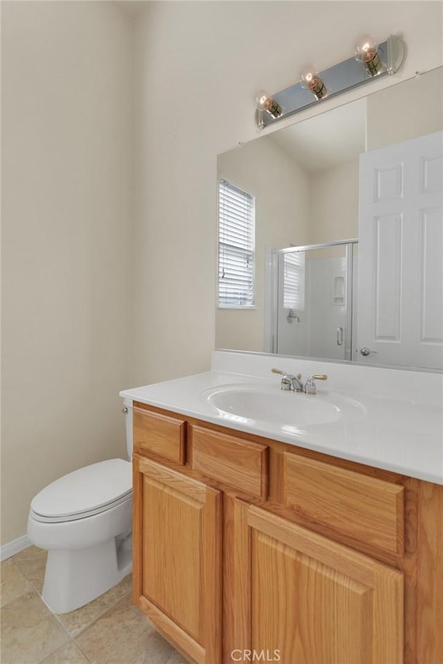 bathroom featuring toilet, vanity, tile patterned floors, and walk in shower