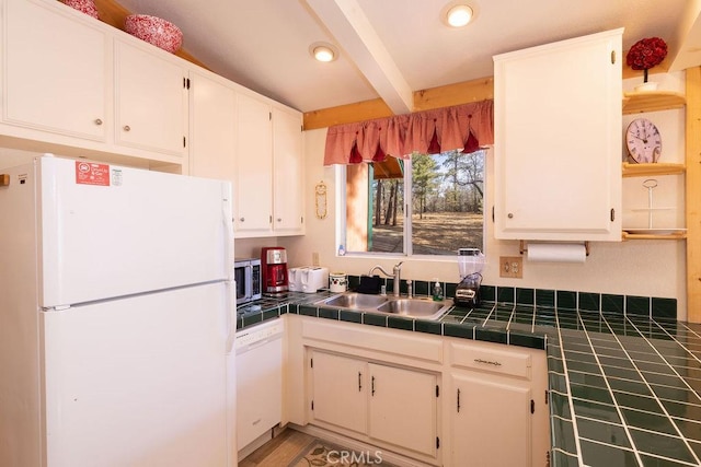 kitchen with white cabinets, white appliances, tile countertops, and sink