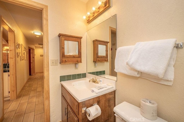 bathroom with hardwood / wood-style floors, vanity, and toilet