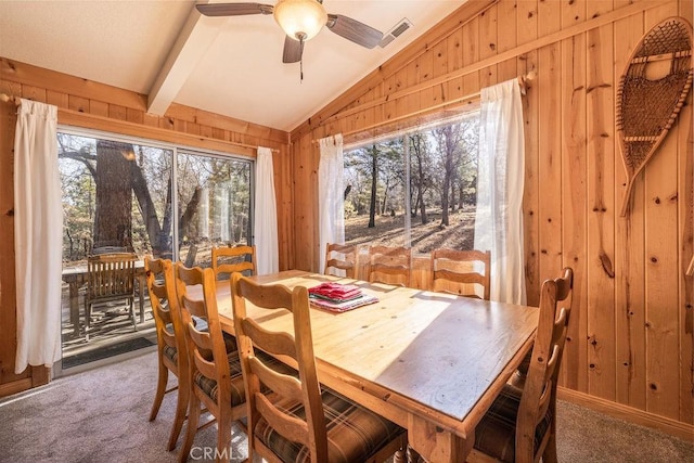 dining space featuring carpet flooring and wooden walls