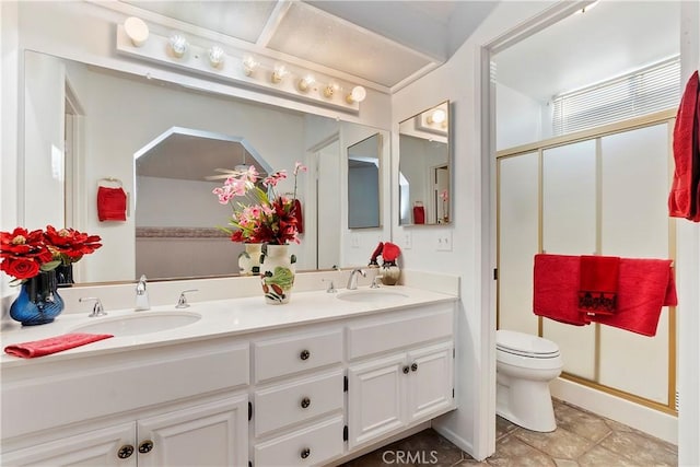 bathroom featuring a shower with shower door, vanity, and toilet