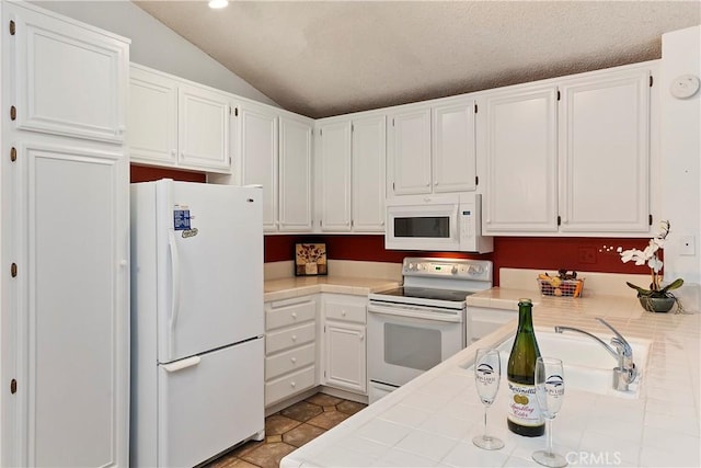 kitchen featuring white appliances and white cabinetry