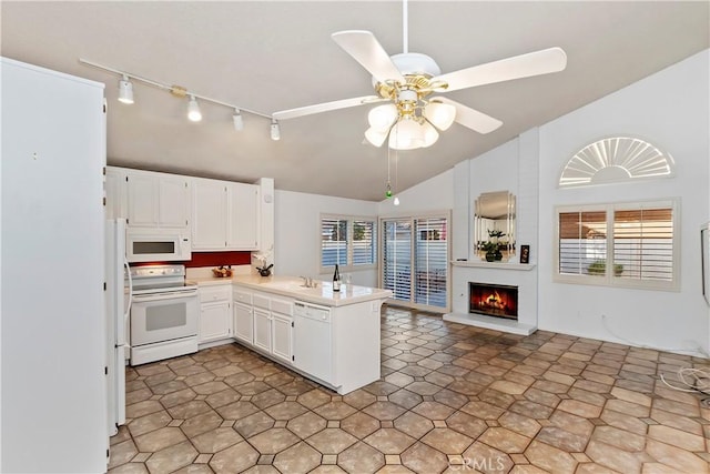 kitchen with ceiling fan, vaulted ceiling, kitchen peninsula, white appliances, and white cabinetry