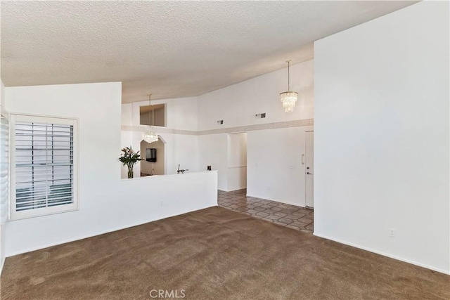 unfurnished room featuring a textured ceiling, a chandelier, dark carpet, and high vaulted ceiling