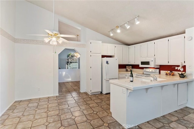 kitchen with kitchen peninsula, ceiling fan, white appliances, lofted ceiling, and white cabinets