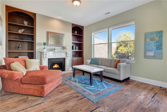 living room with hardwood / wood-style floors and built in shelves