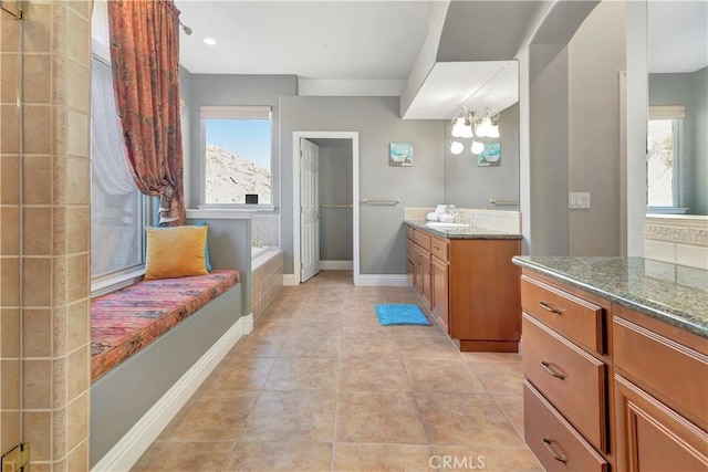 bathroom with tile patterned floors, tiled bath, vanity, and a chandelier