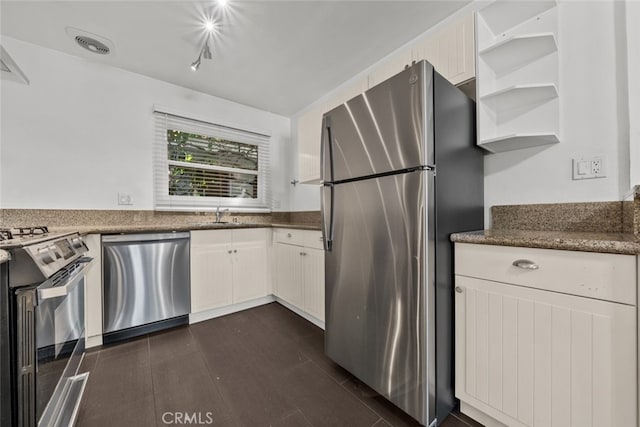 kitchen featuring white cabinetry, sink, appliances with stainless steel finishes, and dark stone counters