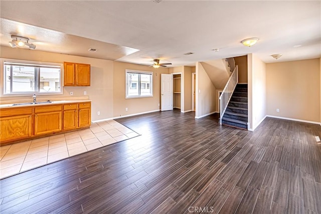 unfurnished living room with ceiling fan, plenty of natural light, light hardwood / wood-style floors, and sink