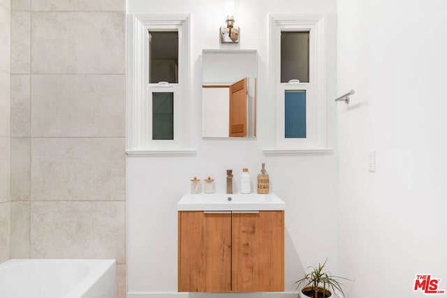 bathroom with vanity and a tub