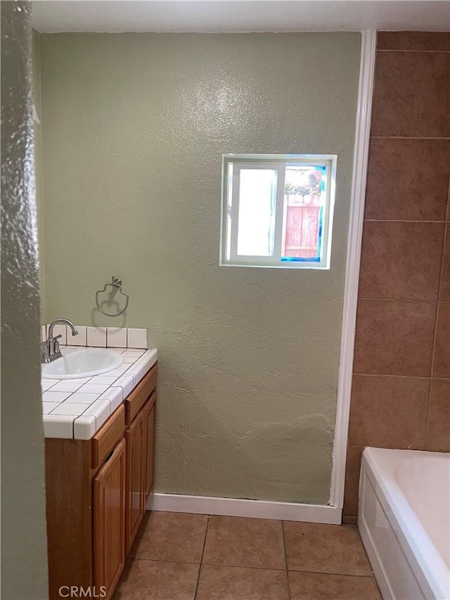 bathroom featuring a tub to relax in, tile patterned flooring, a shower, baseboards, and vanity