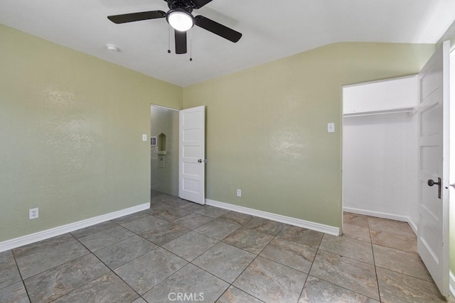 unfurnished bedroom with a closet, a ceiling fan, baseboards, and vaulted ceiling