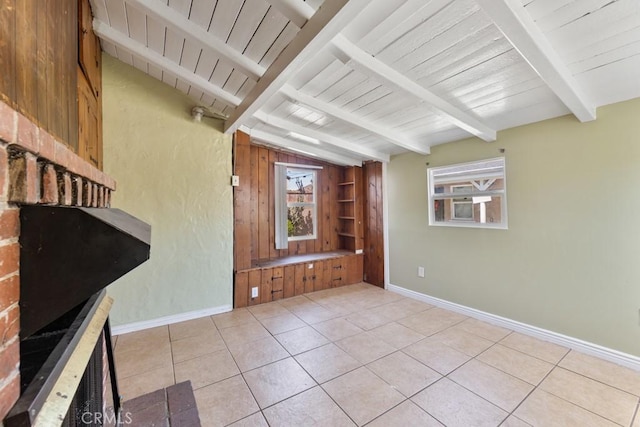 interior space featuring baseboards, light tile patterned flooring, and vaulted ceiling with beams