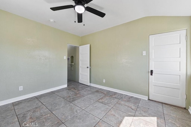 unfurnished room featuring vaulted ceiling, baseboards, and ceiling fan