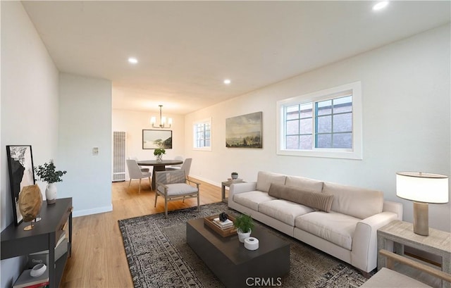 living room with a notable chandelier and light hardwood / wood-style flooring