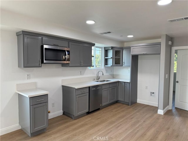 kitchen featuring sink, appliances with stainless steel finishes, and gray cabinetry