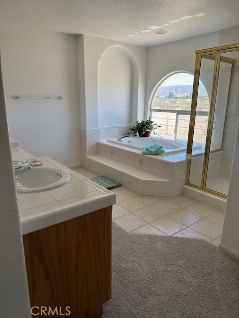 bathroom with tile patterned floors, vanity, a textured ceiling, and plus walk in shower